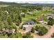 Scenic aerial view of a neighborhood with lush trees and sprawling green fields at 3630 Mesa Verde Rd, Monument, CO 80132