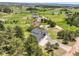 Expansive aerial of home surrounded by lush meadows, and trees under sunny skies at 3630 Mesa Verde Rd, Monument, CO 80132