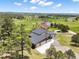 An elevated view showcasing the modern home surrounded by lush greenery and expansive rural fields with mountain views at 3630 Mesa Verde Rd, Monument, CO 80132