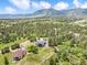 Stunning aerial view showcases the home nestled among lush trees, highlighting the scenic mountain backdrop and neighborhood at 3630 Mesa Verde Rd, Monument, CO 80132