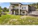 Backyard of the home features lush greenery and a modern two-story house with a large balcony and outdoor stairs at 3630 Mesa Verde Rd, Monument, CO 80132