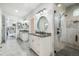 Elegant bathroom featuring dual vanities with marble counters, modern lighting, and a frameless glass shower at 3630 Mesa Verde Rd, Monument, CO 80132