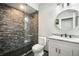 Modern bathroom featuring a textured accent wall, and a vanity with marble countertop and modern fixture at 3630 Mesa Verde Rd, Monument, CO 80132