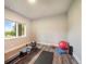 Bright exercise room with wood look flooring, workout equipment, and views of the outdoors at 3630 Mesa Verde Rd, Monument, CO 80132