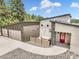 Modern home with a red door, stone accents, and a spacious driveway leading to a two-car garage at 3630 Mesa Verde Rd, Monument, CO 80132