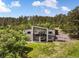 Aerial view showcases a modern home surrounded by lush greenery, highlighting its architectural design and outdoor spaces at 3630 Mesa Verde Rd, Monument, CO 80132