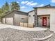 Modern home with stone accents, a vibrant red front door and three car garage at 3630 Mesa Verde Rd, Monument, CO 80132
