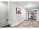 Hallway with gray wood-look floors featuring a grey framed painting, doors, and a grey door with glass panels at 3630 Mesa Verde Rd, Monument, CO 80132