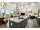 Open kitchen with a marble island, stainless steel appliances, and views of the living room with a stone fireplace at 3630 Mesa Verde Rd, Monument, CO 80132