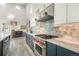 Bright kitchen featuring an oven range, marble countertops, stainless steel appliances, and sleek blue cabinetry at 3630 Mesa Verde Rd, Monument, CO 80132