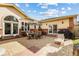 Backyard patio area featuring dining set, grill, brick accents, and view of the home's architecture at 2400 S Clayton St, Denver, CO 80210