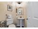Half bathroom featuring a pedestal sink, decorative mirror, overhead lighting, and tiled floors at 2400 S Clayton St, Denver, CO 80210