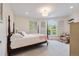 Bedroom featuring a four poster bed, carpet, and an arched window at 2400 S Clayton St, Denver, CO 80210