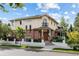 Inviting two-story home showcasing a beige stucco facade complemented by brick accents, a balcony, and manicured landscaping at 2400 S Clayton St, Denver, CO 80210