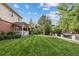 Expansive front yard with a lush lawn, mature trees, and well-maintained landscaping at 2400 S Clayton St, Denver, CO 80210