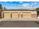 Three-car garage with tan doors and a brick base, offering ample parking at 2400 S Clayton St, Denver, CO 80210