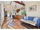 Cozy living room area with hardwood floors, exposed wooden beams, and a comfortable blue sofa at 2400 S Clayton St, Denver, CO 80210
