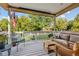Relaxing covered porch with comfortable seating overlooking a well-maintained lawn and the American flag at 2400 S Clayton St, Denver, CO 80210