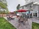 Landscaped backyard with a patio set with a red umbrella, hot tub, and a well-maintained lawn at 4892 S Robb St, Littleton, CO 80127