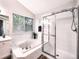 Bathroom features include a tub under a window and a glass-enclosed shower at 4892 S Robb St, Littleton, CO 80127