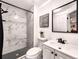 Modern bathroom featuring stylish tile, glass shower, and a contemporary vanity with black accents at 4892 S Robb St, Littleton, CO 80127