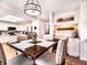 Dining area with a dark wood table, beige upholstered chairs, and modern lighting at 4892 S Robb St, Littleton, CO 80127
