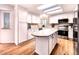 Bright kitchen features white cabinets, stainless steel appliances, and a center island at 4892 S Robb St, Littleton, CO 80127