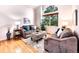 Bright living room featuring vaulted ceiling, hardwood floors, and large windows at 4892 S Robb St, Littleton, CO 80127