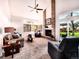 Bright living room with vaulted ceilings, a brick fireplace, a ceiling fan, and sliding glass doors to the backyard at 4892 S Robb St, Littleton, CO 80127