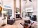 Cozy living room featuring a brick fireplace, neutral colors, and ample natural light from large windows at 4892 S Robb St, Littleton, CO 80127