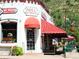 Charming Mill Street shop with a red awning and blooming flowers, creating a welcoming street scene at 4892 S Robb St, Littleton, CO 80127