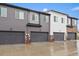 Modern townhome exterior with multiple garages and neutral color scheme at 430 Millwall Cir, Castle Pines, CO 80108