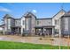 Modern townhouse exteriors with gray siding, large windows, and well-maintained landscaping under a blue sky at 430 Millwall Cir, Castle Pines, CO 80108
