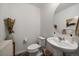 Stylish powder room with a pedestal sink, round mirror, and modern decor at 430 Millwall Cir, Castle Pines, CO 80108