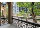 Apartment balcony with an iron railing, offering city views and mature trees at 1210 E Colfax Ave # 302, Denver, CO 80218