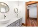 Bathroom featuring double sinks, grey cabinets, modern fixtures, and hardwood flooring at 1210 E Colfax Ave # 302, Denver, CO 80218