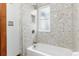 Bathroom features a white tub, shower with decorative herringbone tile, and shower niche at 1210 E Colfax Ave # 302, Denver, CO 80218