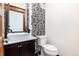 Half bathroom featuring dark wallpaper, dark vanity, and white vessel sink at 1210 E Colfax Ave # 302, Denver, CO 80218