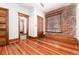 Bedroom featuring exposed brick wall, ceiling fan, and hardwood floors at 1210 E Colfax Ave # 302, Denver, CO 80218