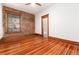 Bedroom featuring exposed brick wall, ceiling fan, and hardwood floors at 1210 E Colfax Ave # 302, Denver, CO 80218