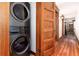 Hallway with hardwood floors and stacked washer and dryer at 1210 E Colfax Ave # 302, Denver, CO 80218