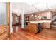 Open-concept living space with exposed brick, fireplace, hardwood floors, and kitchen view at 1210 E Colfax Ave # 302, Denver, CO 80218