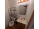 Compact bathroom with a vanity sink, toilet, and storage shelf, designed for functionality and efficiency at 290 W 1St Ave, Broomfield, CO 80020