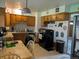 Functional kitchen featuring wooden cabinets, black appliances, and a dining area for casual meals at 290 W 1St Ave, Broomfield, CO 80020