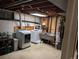 Unfinished basement laundry area includes washer, dryer, utility sink, and hot water heater at 290 W 1St Ave, Broomfield, CO 80020