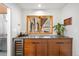 Stylish bar area with wood cabinets, beverage cooler, countertop, and view from a window to the outside at 1943 Columbine Ct, Golden, CO 80401