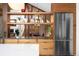 Modern kitchen design with wood cabinetry, stainless steel refrigerator, and open shelving above countertop at 1943 Columbine Ct, Golden, CO 80401