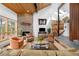 Inviting living room featuring a stone fireplace, wood ceiling, and large windows with scenic outdoor views at 1943 Columbine Ct, Golden, CO 80401