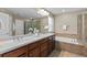 This bathroom features a double sink vanity, framed mirror, soaking tub, and glass-enclosed shower at 2776 Badlands Ct, Castle Rock, CO 80109