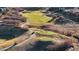 Aerial view of golf course with people playing in a vibrant and scenic community at 2776 Badlands Ct, Castle Rock, CO 80109